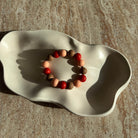 Komplettes Caramel Ember Armband in einer cremefarbenen Schale, warmes Farbspiel.