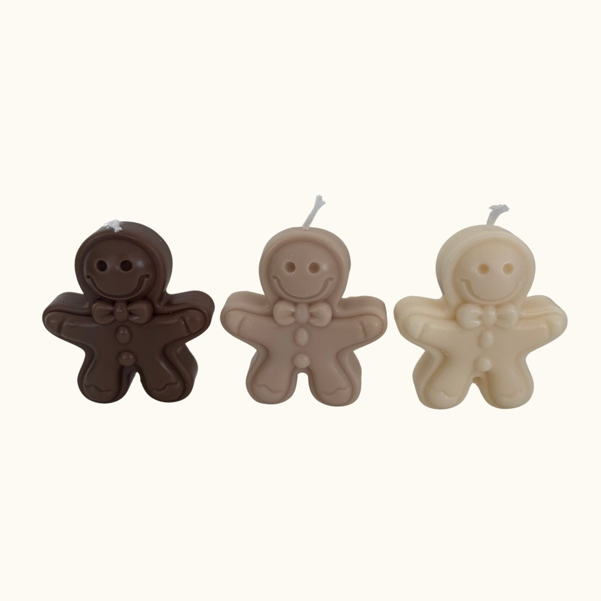 „Detailaufnahme des Gingerbread Trios aus schräger Perspektive – drei farblich unterschiedliche Gingerbread-Kerzen in einer winterlichen Schale.“