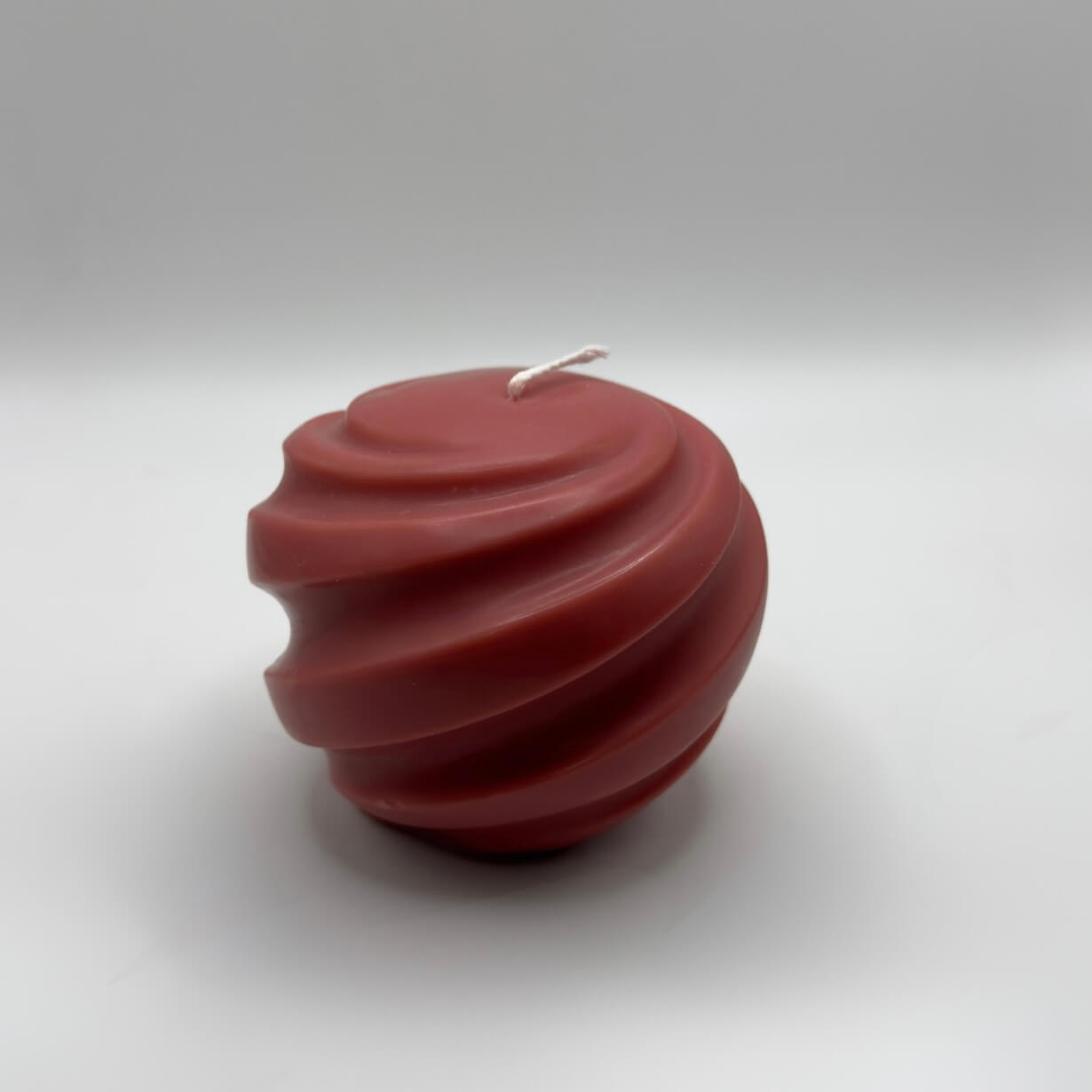 Die „Ribbed Christmas Bauble“ Kerze in Rot ist eine handgefertigte Sojawachs-Kerze in Kugelform mit eleganten Spiralrillen – ein stilvoller Blickfang für die Weihnachtszeit.